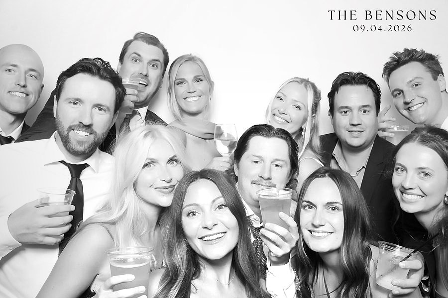 Large group of wedding guests packed into a black and white glam booth photo