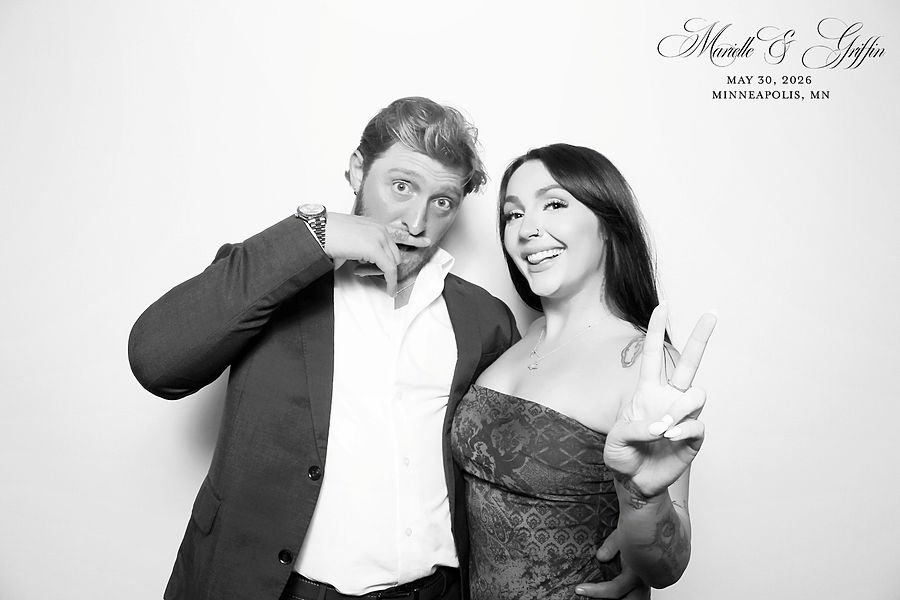 Playful couple posing in a glam photo booth at a Minneapolis wedding