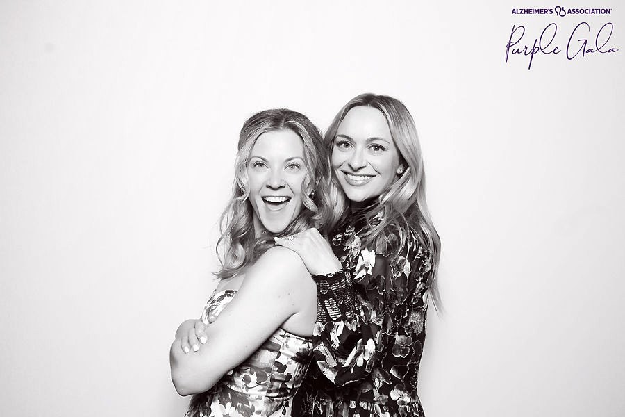 Two women laughing in a glam photo booth portrait at the Alzheimer's Association Purple Gala