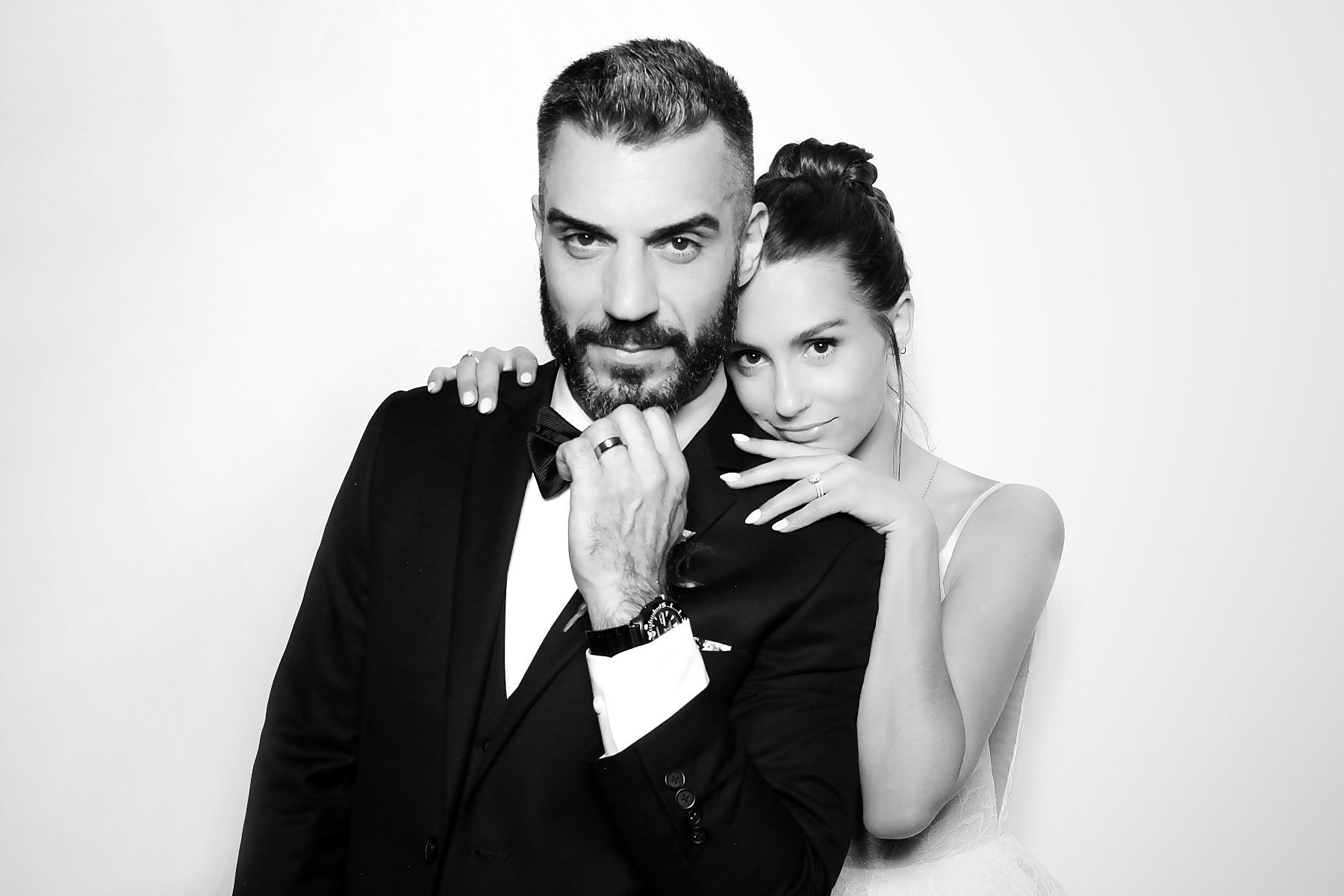 Couple in a tuxedo and white dress posing in a black and white glam photo booth in Minneapolis