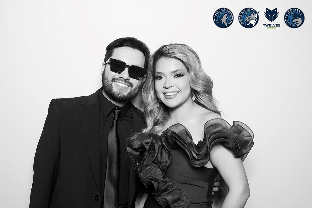 Couple in formal wear posing in a glam photo booth branded with Minnesota Timberwolves logos