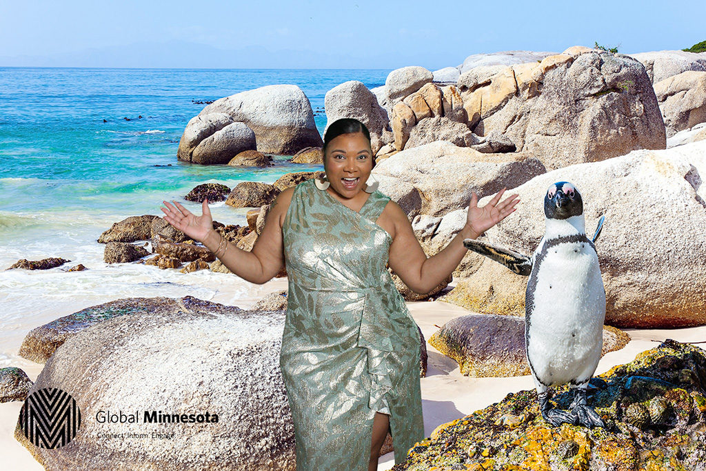 Global Minnesota green screen photo of a guest on a sunny beach next to a penguin