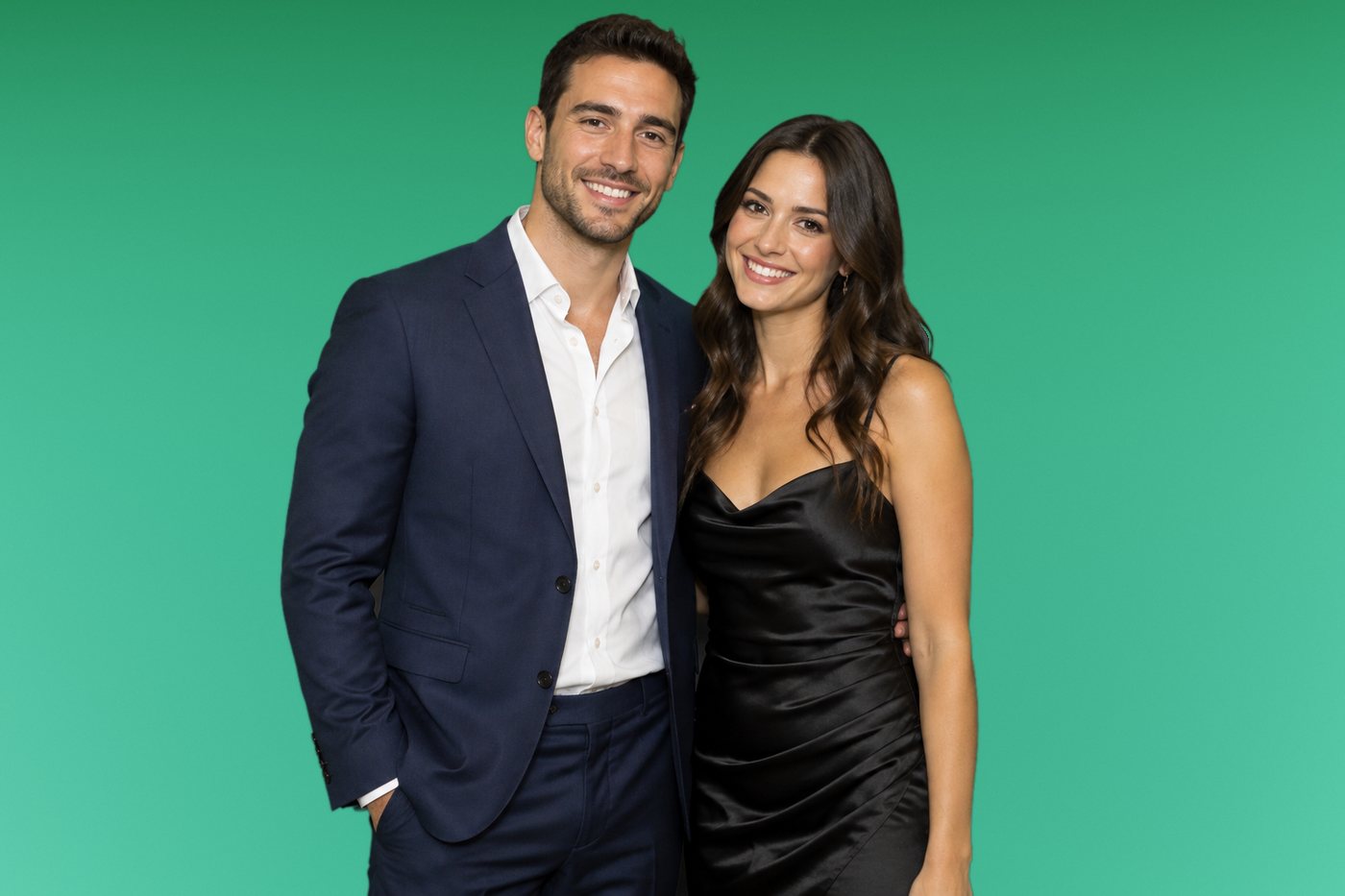 Stylish couple in a navy suit and black satin dress in front of a green screen
