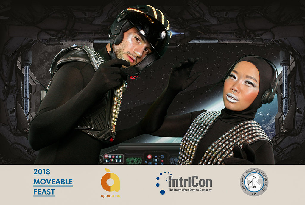 Sci fi green screen photo of two guests in space suits inside a spaceship cockpit at a Minneapolis gala