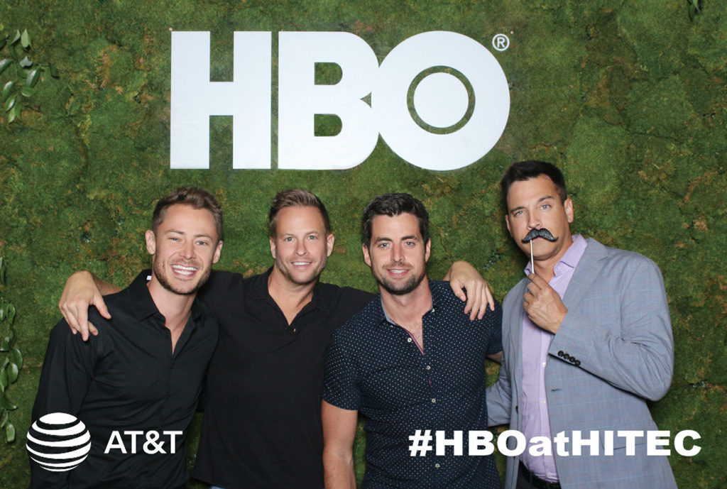 HBO branded trade show print of four men in front of a moss wall logo