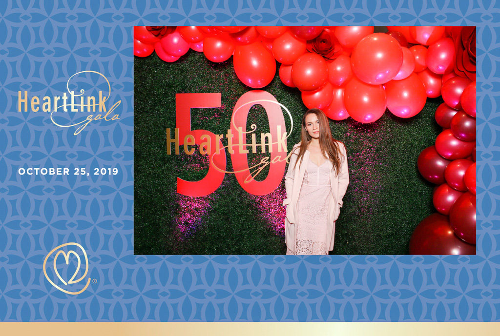 HeartLink gala 50th anniversary print of a guest in front of a red balloon wall