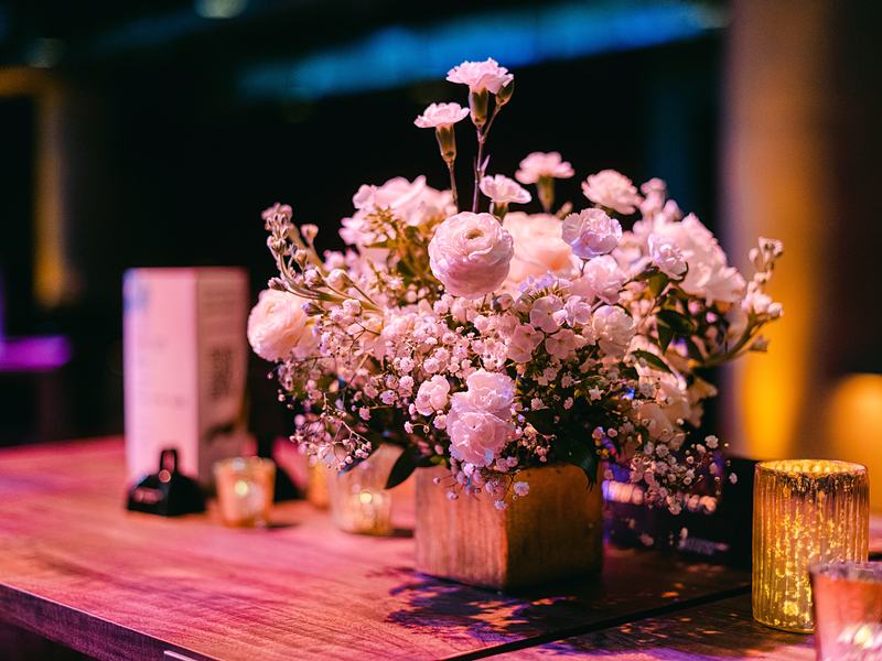 Pink florals and candles on a cocktail table at an awards gala