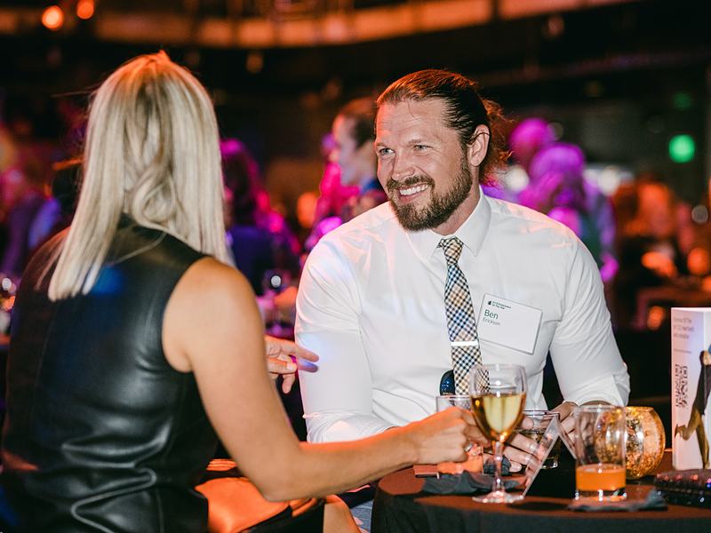 Guests laughing over drinks at a gala table