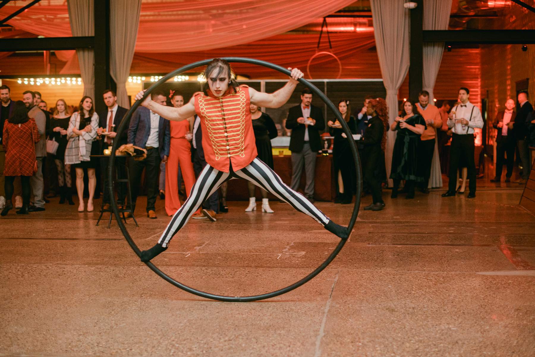 Cyr wheel performer spinning in front of a crowd of guests at a corporate event