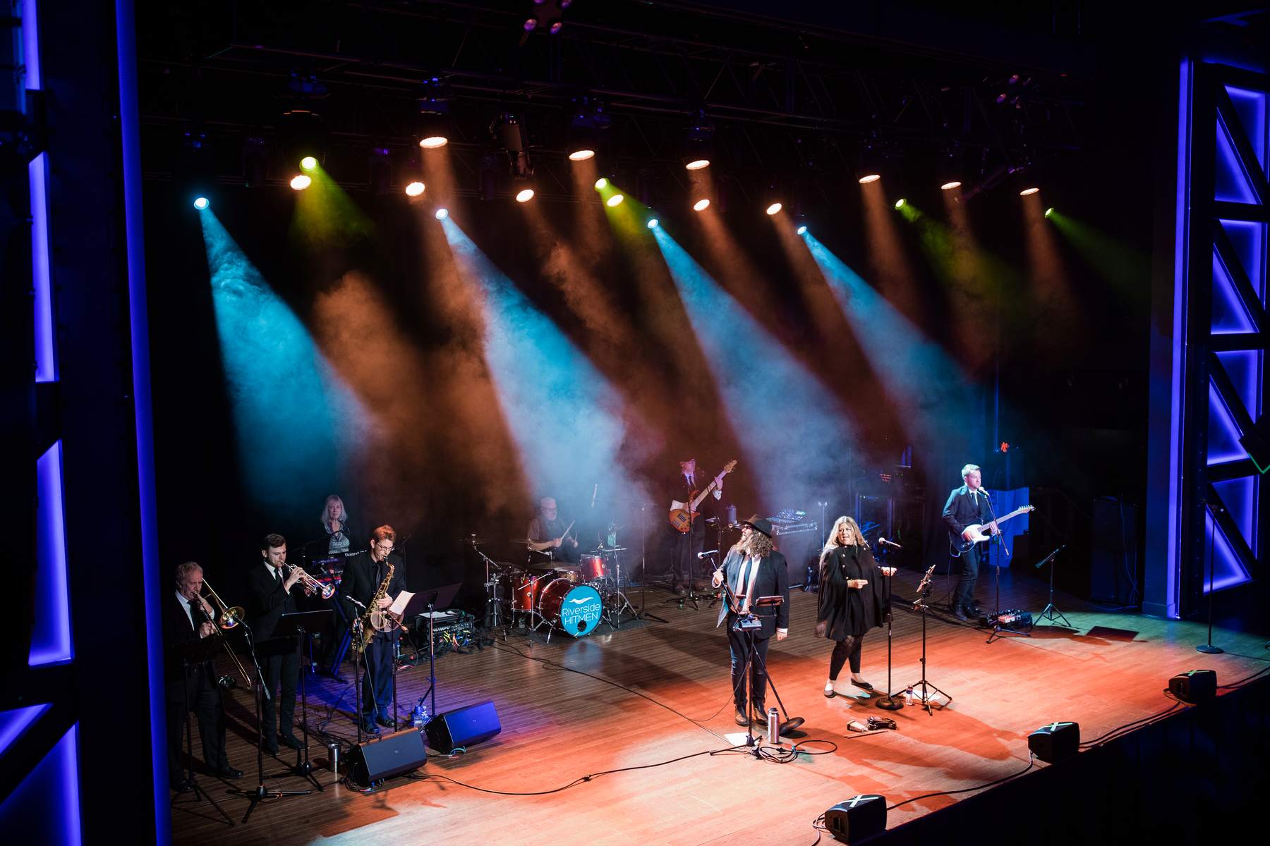 Live band on stage under teal and green spotlights at a corporate event in Minneapolis