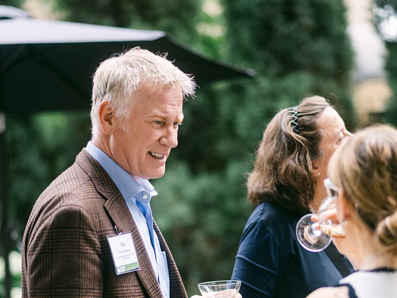 Guests networking on a patio at a summer celebration
