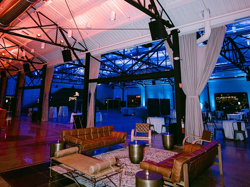 Warehouse event venue lit in blue and pink before guests arrive