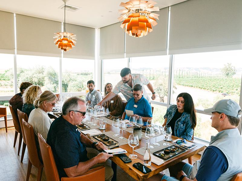 Long lunch table with guests at a winery client event