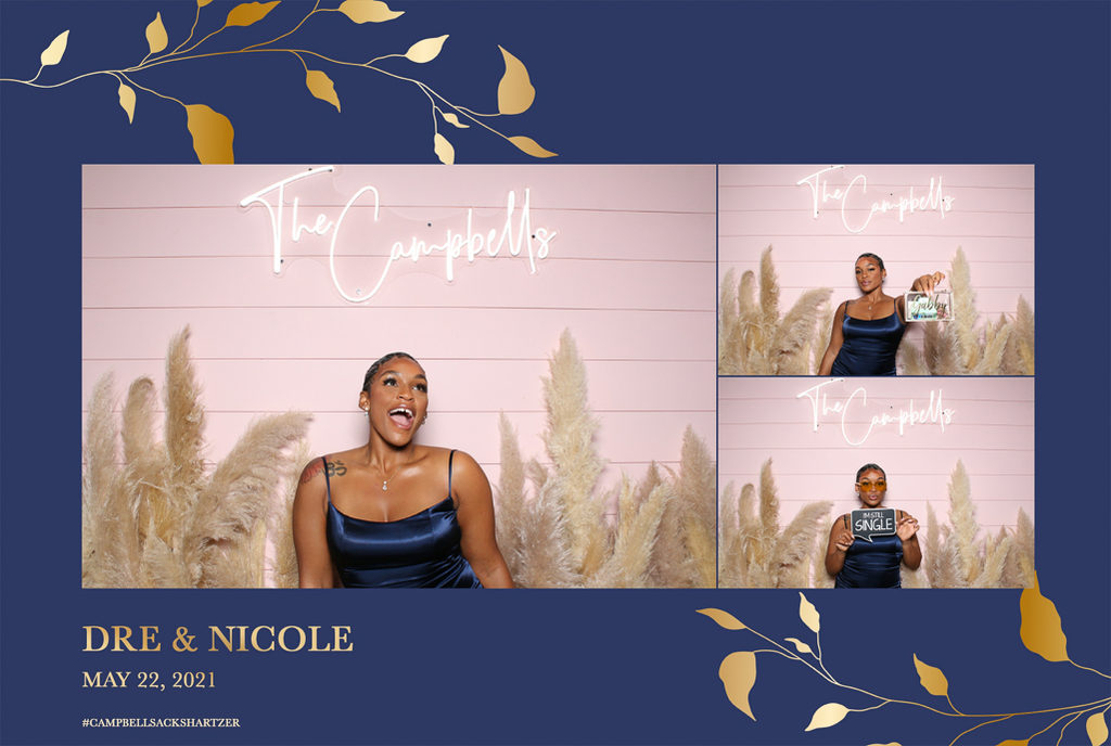 Navy and gold wedding print with a guest in front of a pink wall with pampas grass and a neon name sign