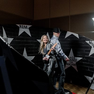 Guests posing at an open style photo booth whose photos feed the mosaic wall