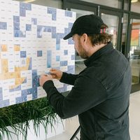 TIP attendant placing photo tiles on a mosaic board