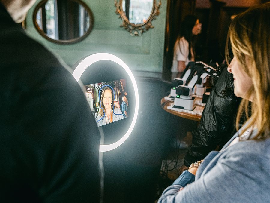 Guest posing for a Sketch Bot photo in front of a ring light screen at a restaurant event
