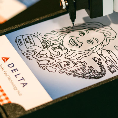 Sketch Bot robot arm drawing a pen portrait on a Delta branded card at a Minneapolis corporate event