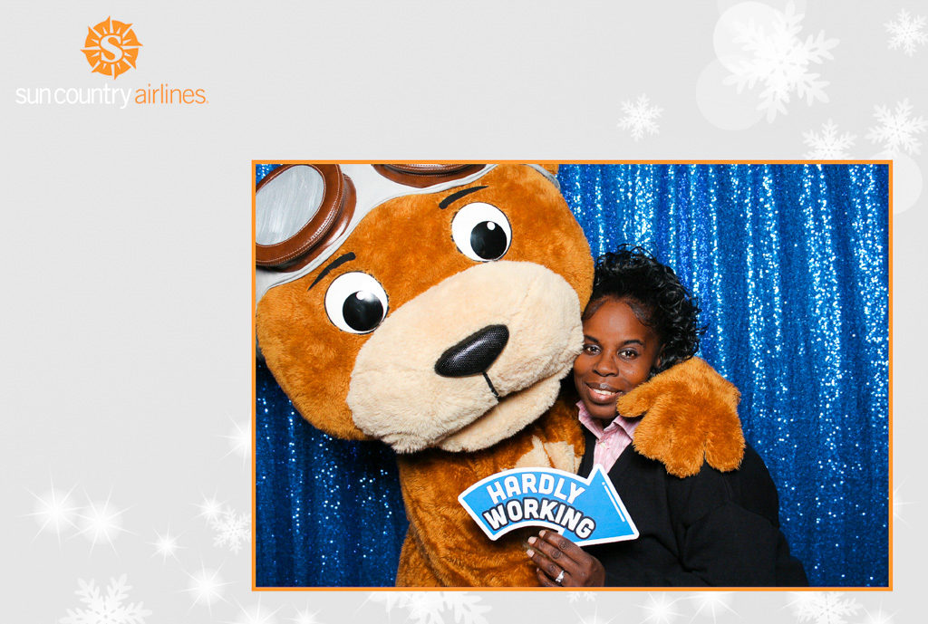 Sun Country Airlines holiday party print of an employee hugging a bear mascot on blue sequins