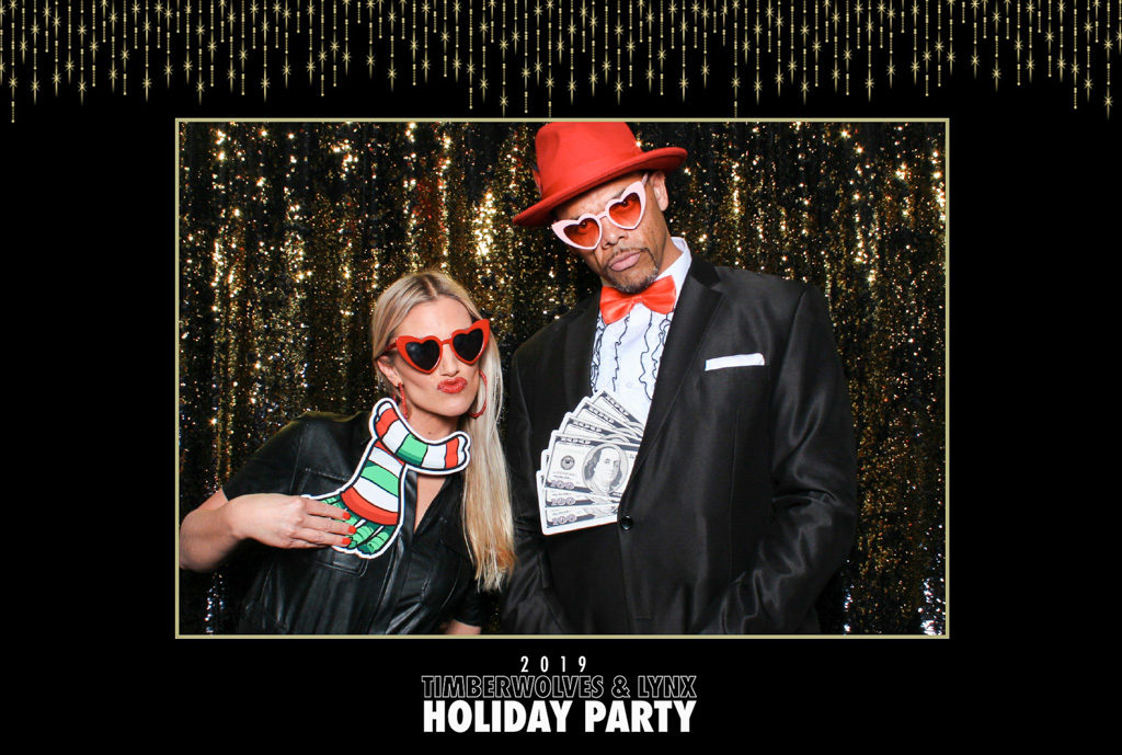 Timberwolves and Lynx holiday party large print of a couple with heart sunglasses and money props