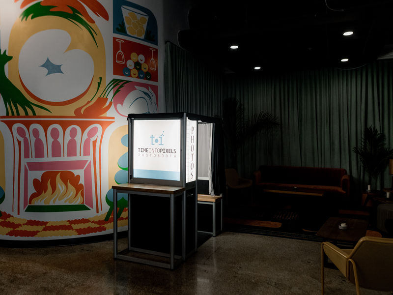 Traditional photo booth rental in a Minneapolis lounge with a colorful mural