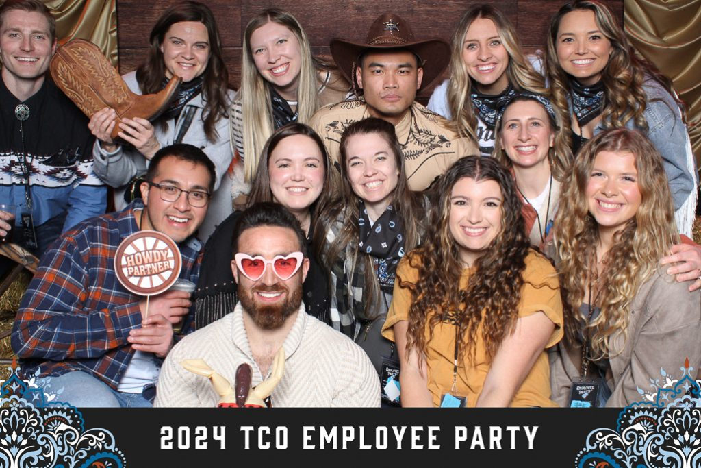 Western themed 2024 employee party print with a big group in cowboy hats and bandanas