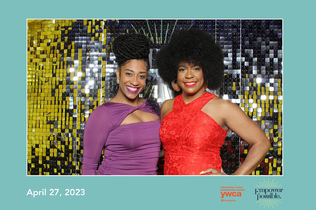 YWCA Minneapolis gala print of two women in front of a gold and silver shimmer wall